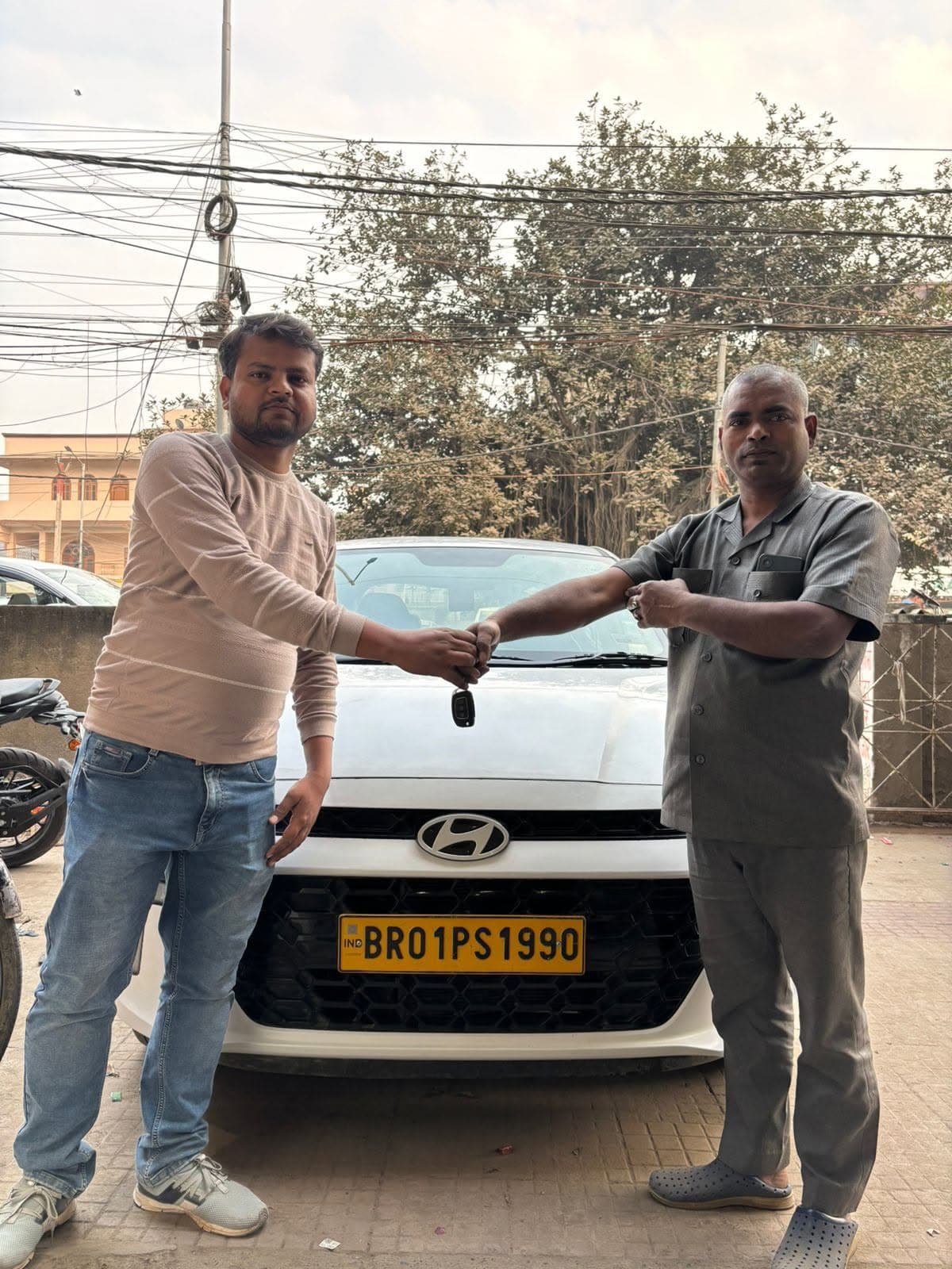 Happy customer receiving car keys for Hyundai Grand i10